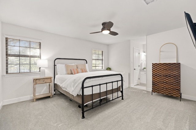 bedroom featuring ceiling fan, connected bathroom, and light carpet