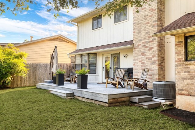 back of property featuring a yard, a deck, and central air condition unit