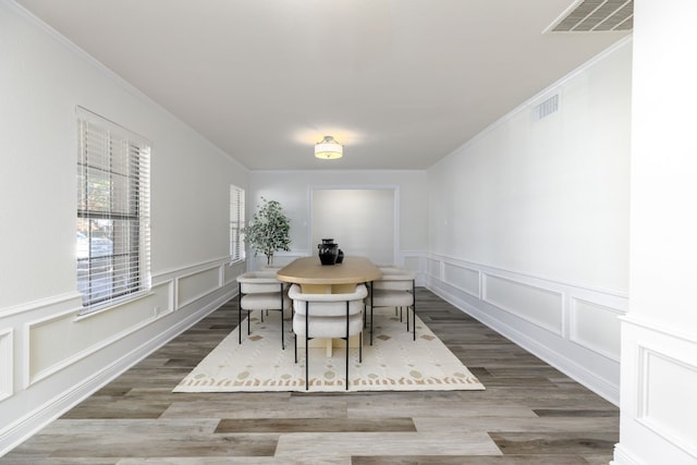 dining area with crown molding and hardwood / wood-style floors