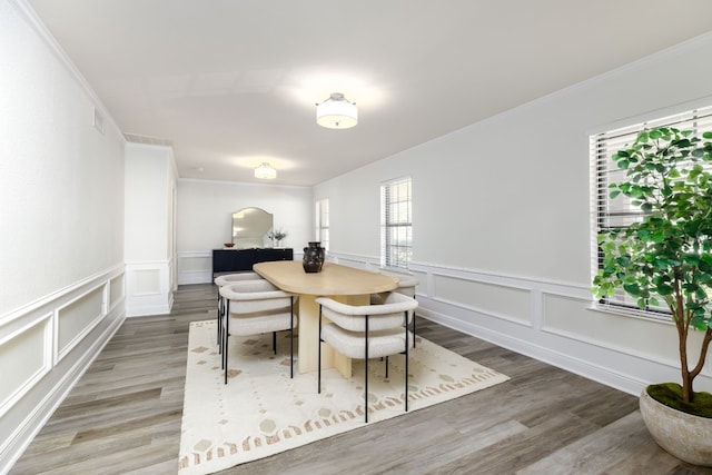 dining room with crown molding and hardwood / wood-style floors