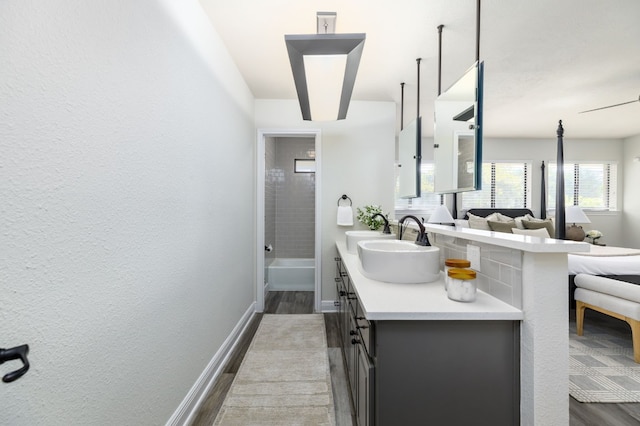 bathroom featuring hardwood / wood-style flooring, tiled shower / bath combo, and vanity