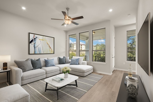 living room with light wood-type flooring and ceiling fan