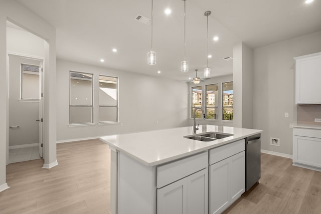 kitchen with sink, white cabinetry, stainless steel dishwasher, and a kitchen island with sink