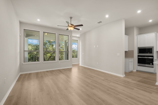 unfurnished living room featuring ceiling fan and light hardwood / wood-style flooring