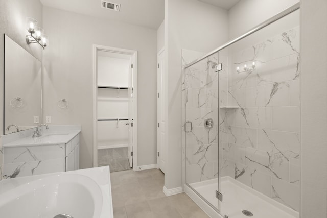 bathroom featuring vanity, a shower with shower door, and tile patterned flooring