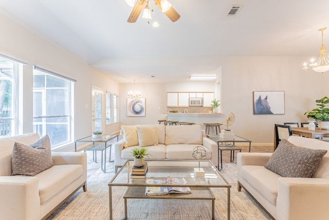 living room featuring ceiling fan with notable chandelier