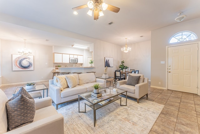 living room with ceiling fan with notable chandelier