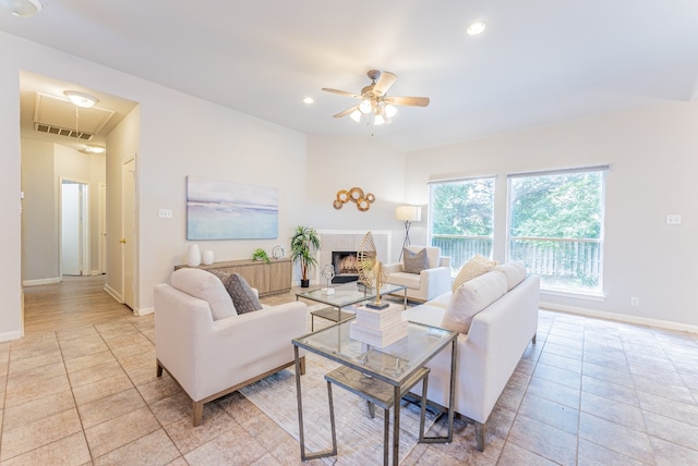 living room featuring a tiled fireplace and ceiling fan