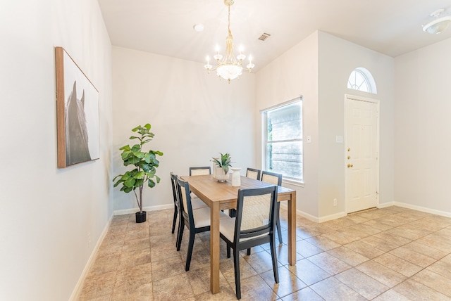 dining room with plenty of natural light, light tile patterned floors, and a chandelier