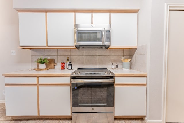 kitchen featuring white cabinetry, decorative backsplash, and stainless steel appliances