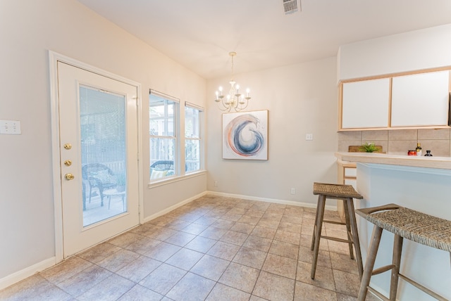 unfurnished dining area with light tile patterned floors and a notable chandelier