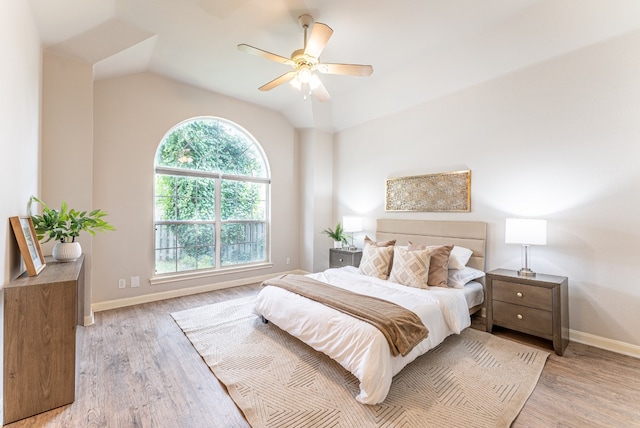 bedroom featuring ceiling fan, light wood-type flooring, and lofted ceiling