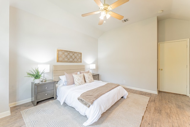 bedroom with ceiling fan, light hardwood / wood-style floors, and lofted ceiling