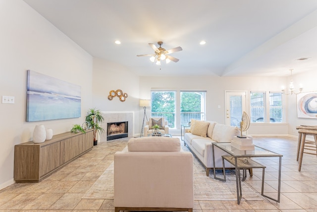 living room with a fireplace and ceiling fan with notable chandelier