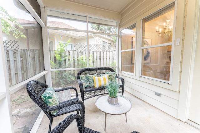 sunroom / solarium featuring a notable chandelier