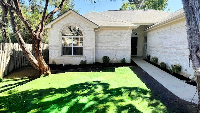 view of exterior entry featuring a lawn