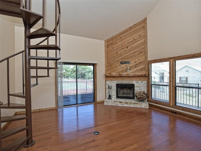 unfurnished living room with a fireplace, hardwood / wood-style floors, and high vaulted ceiling