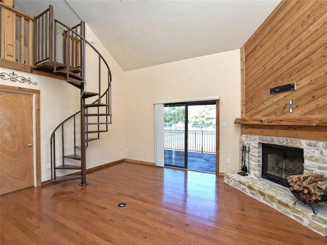 unfurnished living room with wood-type flooring, a fireplace, and vaulted ceiling