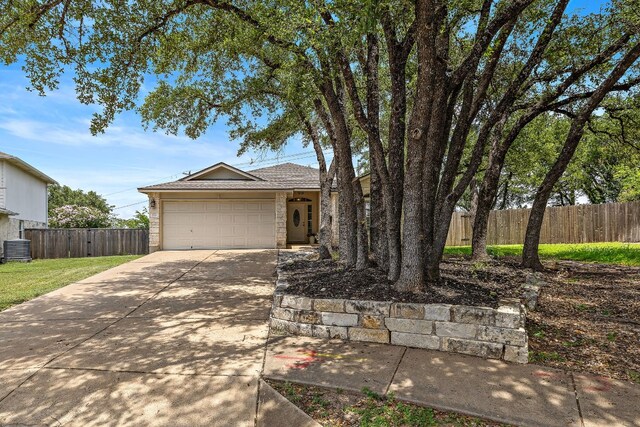 ranch-style house featuring a garage and central AC