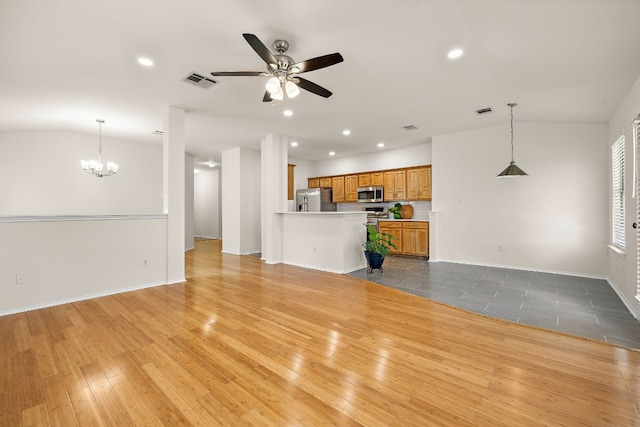 unfurnished living room featuring lofted ceiling, light hardwood / wood-style floors, and ceiling fan with notable chandelier