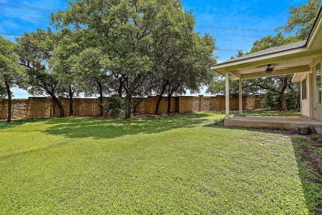 view of yard with ceiling fan and a patio area