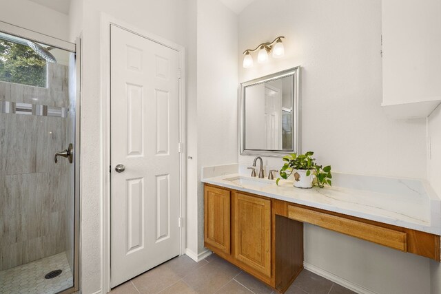 bathroom featuring tile flooring, an enclosed shower, and vanity