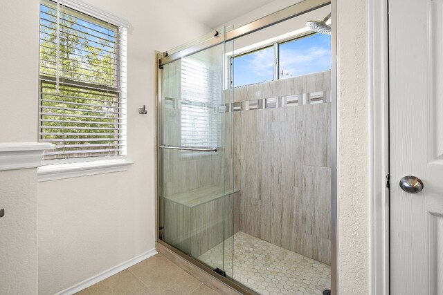 bathroom featuring a shower with shower door and tile flooring