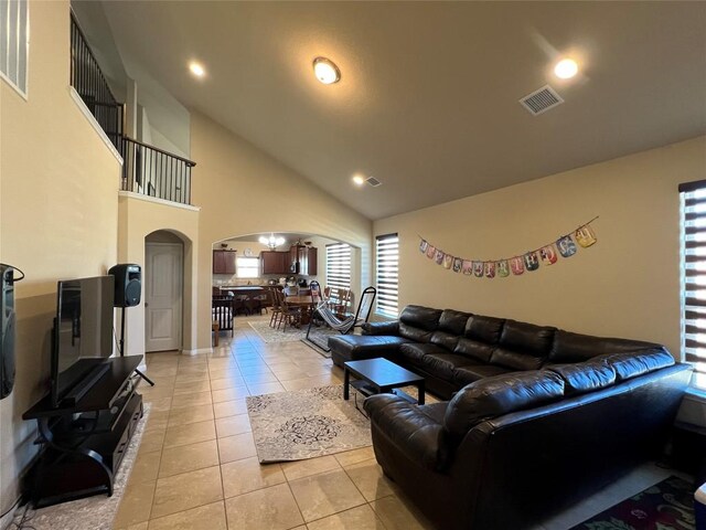 living room with high vaulted ceiling and light tile floors