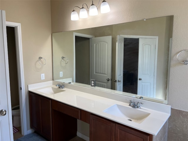 bathroom with double vanity and toilet