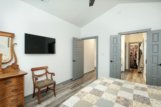 bedroom featuring a spacious closet, light hardwood / wood-style flooring, a closet, high vaulted ceiling, and ceiling fan