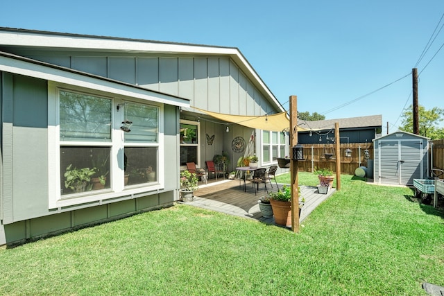 rear view of house with a lawn, a storage unit, and a patio