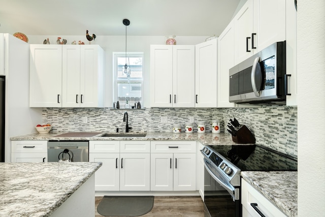 kitchen featuring appliances with stainless steel finishes, white cabinetry, and sink