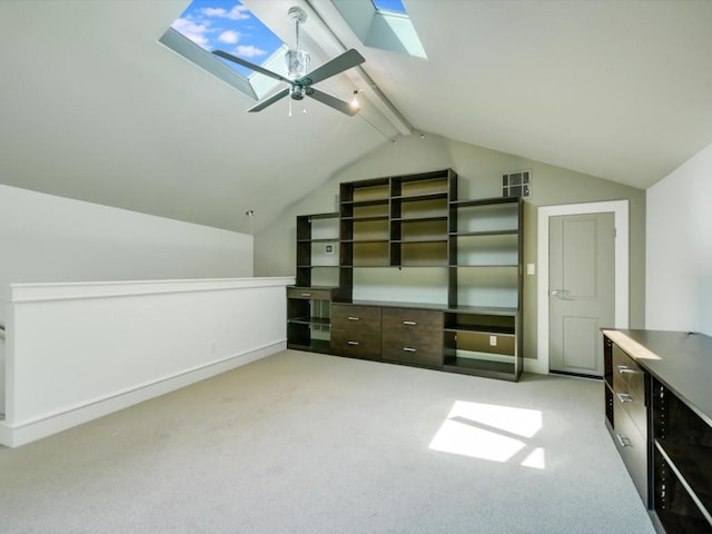 bonus room featuring ceiling fan, vaulted ceiling with skylight, and light carpet