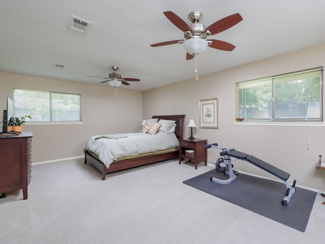 carpeted bedroom with multiple windows and ceiling fan