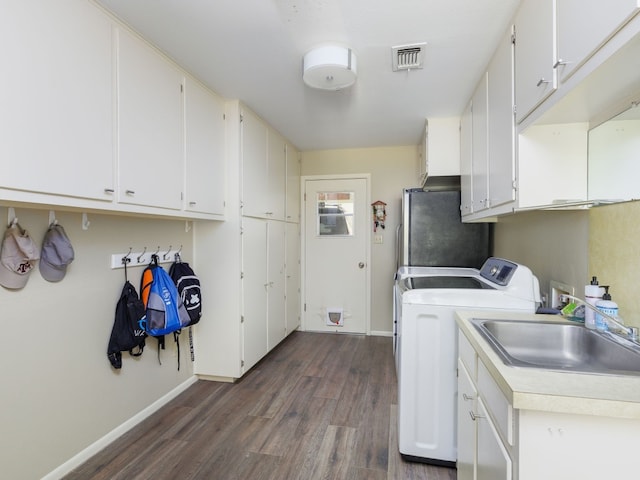 laundry area with cabinets, dark hardwood / wood-style flooring, sink, and washing machine and clothes dryer