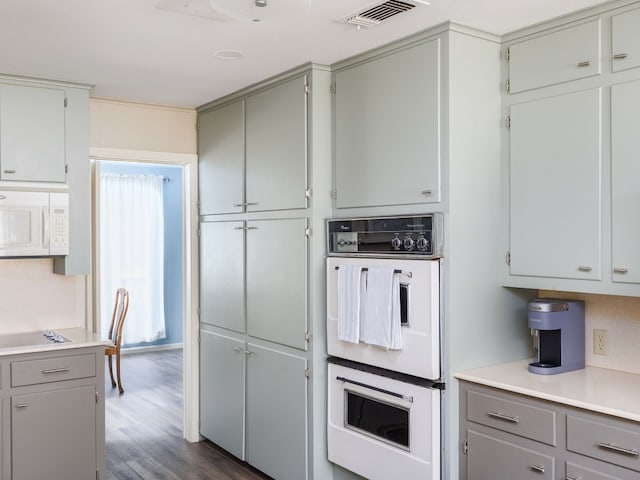 kitchen with white appliances, dark hardwood / wood-style floors, and gray cabinets