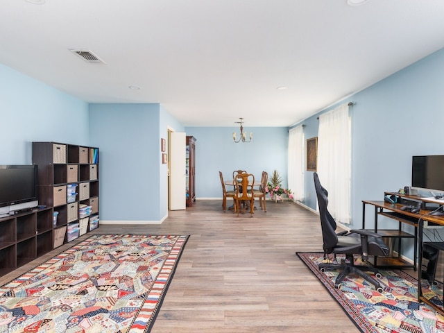 home office with a notable chandelier and light wood-type flooring