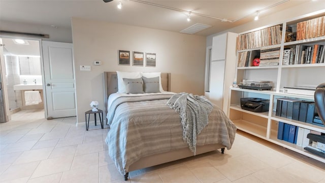 bedroom featuring light tile patterned floors and track lighting