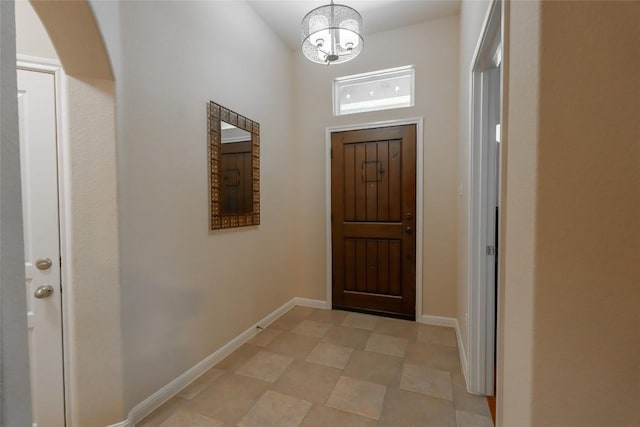 doorway to outside with an inviting chandelier and baseboards