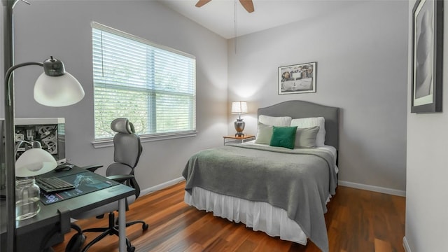 bedroom featuring wood finished floors, a ceiling fan, and baseboards