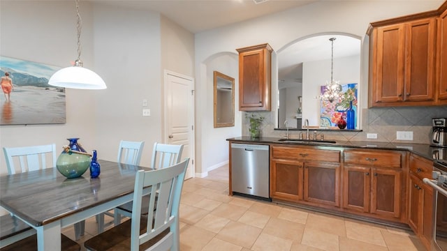 kitchen featuring decorative light fixtures, brown cabinets, backsplash, a sink, and dishwasher