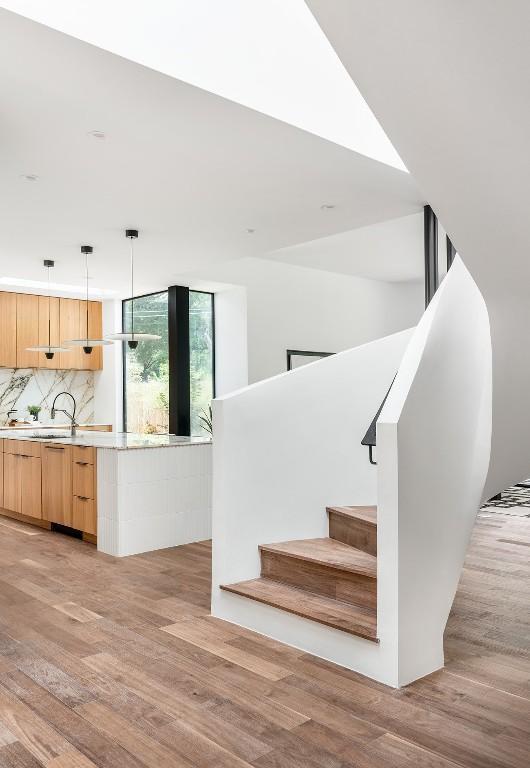 stairs featuring hardwood / wood-style floors and sink