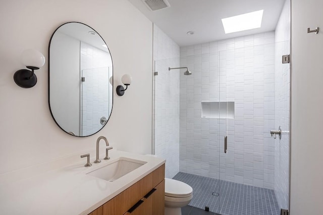 bathroom featuring vanity, a skylight, toilet, and walk in shower