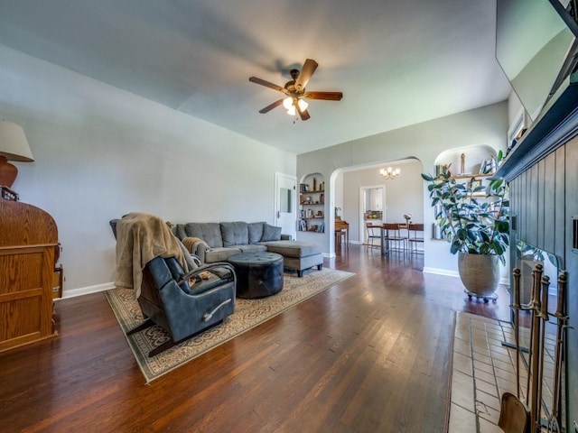 living room featuring dark hardwood / wood-style floors and ceiling fan with notable chandelier