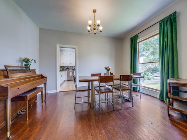 dining room featuring wood-type flooring and an inviting chandelier