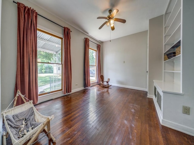 unfurnished living room featuring ceiling fan and dark hardwood / wood-style flooring