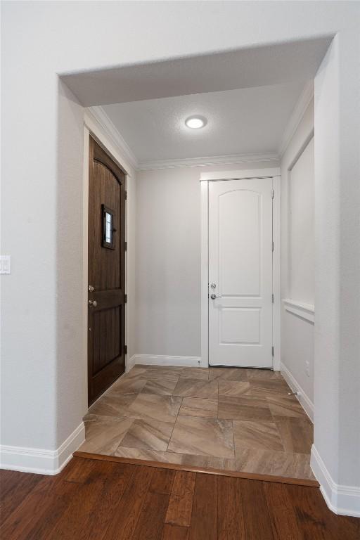 entrance foyer featuring ornamental molding and hardwood / wood-style flooring