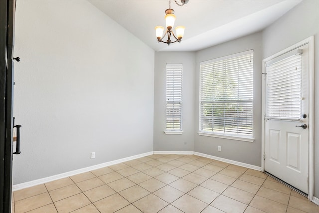 unfurnished room featuring a chandelier and light tile patterned floors