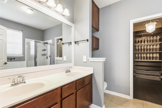 bathroom with vanity, tile patterned flooring, an enclosed shower, and toilet