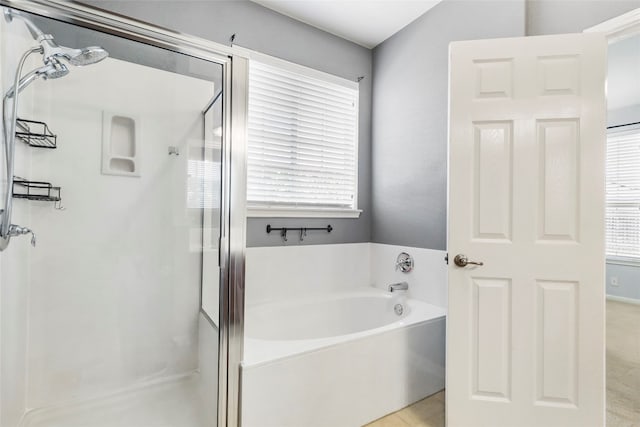 bathroom featuring shower with separate bathtub